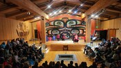 Guests watch the Sheet'ká Ḵwáan Naa Kahídi Dancers wearing traditional regalia