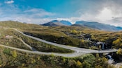 Roads running through a verdant mountainside with a few remote houses