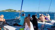 Guests sitting on the back of a catamaran, looking out towards the ocean