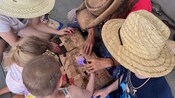Guests gathered around a table examine a treasure map that’s also a puzzle