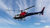 A Helitrans Airbus helicopter flying in the sky