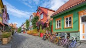 A row of colorful buildings with bikes parked on the side on Fargegaten Street in Stavanger, Norway