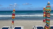 Folded lounge chairs and umbrellas on a sandy beach