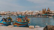 Pequeños barcos de pesca en un puerto y una ciudad en la costa