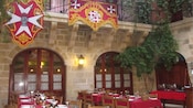 Mesas de jantar do restaurante em um pátio de pedra, decorados com banners
