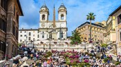 People sitting on the Spanish Steps near the Church of Santissima Trinità dei Monti in Rome