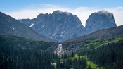 Alaskan landscape featuring rocky mountains, a cascade and a forest in Skagway