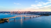 A long bridge spanning across a harbor to a cosmopolitan city