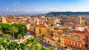 Aerial view of Cagliari, Italy, featuring buildings near palm trees