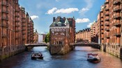 A moated castle with boats and historic buildings in Hamburg, Germany’s warehouse district. 