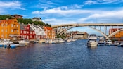 Houses overlooking a harbor in Haugesund, Norway with a bridge and docked boats