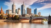 The Melbourne cityscape reveals a vintage church and skyscrapers next to a river and bridge