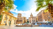 The old town square in Valencia, Spain reveals a splashing fountain surrounded by ornate architecture
