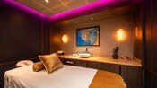 A treatment room at Opulence Spa Elemis at Sea featuring a bed, a long countertop and a sink
