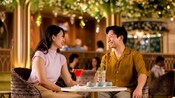 A couple smiles while dining at Tiana’s Bayou Lounge on board the Disney Adventure