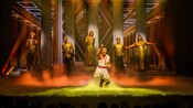 Performers on stage during a theatrical production of Disney Hercules aboard the Disney Destiny cruise ship