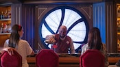 A bartender pouring a cocktail for Guests at The Sanctum, a bar aboard the Disney Destiny cruise ship
