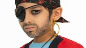 A boy wearing a pirate costume with pirate makeup, a bandana and a single earring