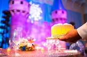 A cake being set on a decorated table for a special event