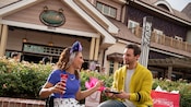 A young couple enjoys cake and sparkling wine outside Amorette’s Patisserie at Disney Springs