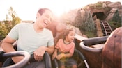 Un padre y su hija viajan en el Seven Dwarfs Mine Train en Magic Kingdom Park de Disney
