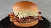 Blues Burger featuring a hamburger with bleu cheese, caramelized onions, bacon and garlic aioli 