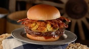 Un cheeseburger avec bacon et macaroni au-dessus