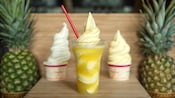DOLE Whip soft serve in cups on both sides of a DOLE Whip float