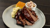 Peito bovino assado e burnt ends com purê de batatas, salada de repolho e pão de milho do Roaring Fork no Disney’s Wilderness Lodge