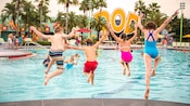 4 niños se zambullen en una piscina al aire libre en Disney’s Pop Century Resort