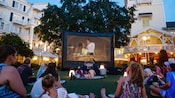 Families on the lawn at night watching The Princess and the Frog at a resort in Walt Disney World
