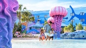 A father playing with his 2 daughters in The Big Blue Pool at Disney’s Art of Animation Resort 