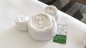 A set of hotel towels rolled and shaped into a decorative Mickey Mouse design