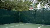 An outdoor basketball court at Disney’s Old Key West Resort, surrounded by a fence and greenery