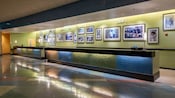 A front desk and check-in area with framed pictures of moments in sports and pop culture, divided by decade ATM