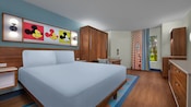 Habitación de hotel preferencial con una cama Queen Size junto a una mesa y sillas en Disney's Pop Century Resort