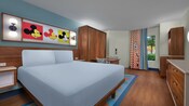 Habitación de hotel estándar con una cama Queen Size junto a una mesa y sillas, con vista a la piscina, en Disney's Pop Century Resort