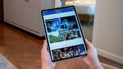 A hand holding a tablet displaying the Disney Parks website in a room at Disney’s Riviera Resort