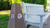 A wooden bench with a cigarette butt receptacle next to it at Disney’s Yacht Club Resort