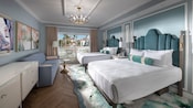 Une chambre d'hôtel avec 2 gros lits, un canapé, une commode et une fenêtre