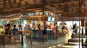 Representación artística de Huéspedes que cenan y beben en un bar al aire libre en Disney Lakeshore Lodge