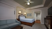 Une chambre d'hôtel avec un lit, canapé et téléviseur mural