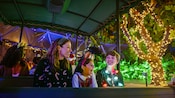 A mother and her 2 children delight in the festive lights at Epcot 