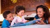 Mother and young child enjoy reading a book together in the bed of their hotel room. Mother and young child enjoy reading a book together in the bed of their hotel room.