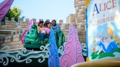 A family of 4 riding through an outdoor section of Alice in Wonderland