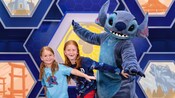 Two young Guests posing for a picture with Stitch in Disney California Adventure Park