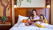 A mother reads a bedtime story to her kids in a Disneyland Resort hotel room