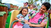 A father and daughter are smiling while riding the Chip N Dales Gadget Coaster, in Mickeys Toontown at Disneyland Park