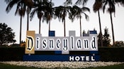 A sign reading ‘Disneyland Hotel’ surrounded by palm trees