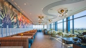 The dining area at High Key Club at the Disneyland Hotel with a music themed mural and large windows overlooking the Disneyland Resort